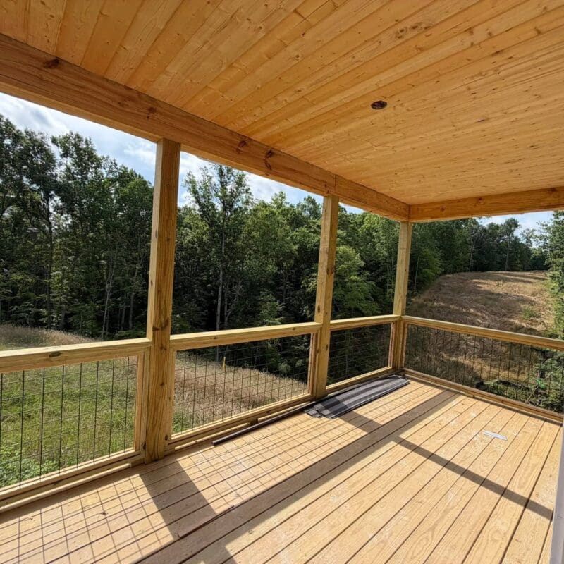 Spacious covered deck with tongue-and-groove wood ceiling, pressure-treated decking, and open Wild Hog railings designed for luxury outdoor living in Middle Tennessee